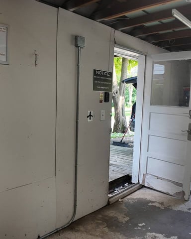 JuiceBox electric vehicle charging station in covered garage with charging rate sign and coiled cable on wall